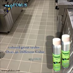 two spray bottles sitting on the floor in a kitchen next to an oven and counter