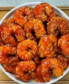 a white bowl filled with chicken wings covered in sauce