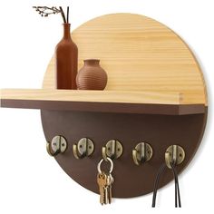 a wooden shelf with key hooks and a vase on it's side next to a set of keys