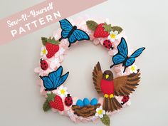 a paper wreath with birds and flowers on it