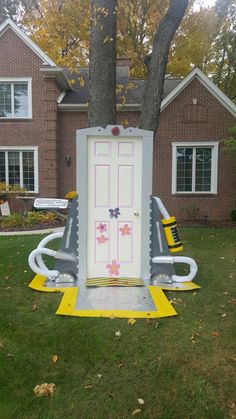 an inflatable door sitting on the grass next to a tree