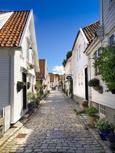 a cobblestone street lined with white houses