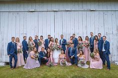 a large group of people standing in front of a barn