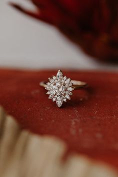 a diamond ring sitting on top of a red cloth