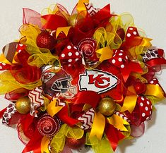 a football wreath is decorated with red, yellow and white bows that have the number 13 on it