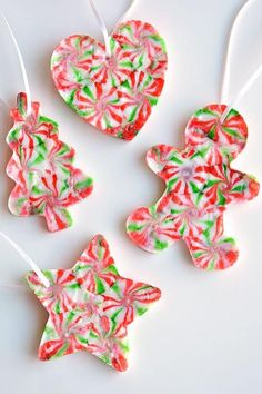 three ornaments made out of candy canes on a white surface