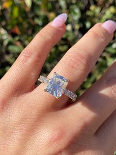 a woman's hand with a diamond ring on it