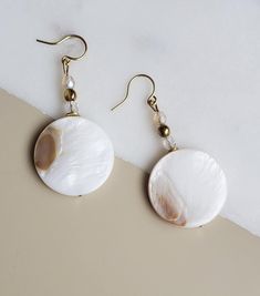 Solazur earrings "Shella" --- Beautiful. Different. Feminine elegance. These earrings will add a pop of style and a boho breeze to your outfit. Seashells are the best summer and beach reminder, and wearing them will make you feel you're on vacation every day :-)  A blend of shell and glass, with an intricate glass shine while the shell's texture reflects its pearly glow from different angles.  The shell coins have a different pattern on each side. They will match beautiful with either a dress or Elegant Pearl White Jewelry For Beach, Elegant Summer Beaded Drop Earrings, Handmade White Earrings In Mother Of Pearl, Elegant Pearl Earrings For Summer, Bohemian White Pearl Earrings, Pearl Drop Shell As A Gift, Elegant Shell-shaped Earrings For Vacation, White Pearl Beaded Bohemian Earrings, White Bohemian Dangle Pearl Earrings