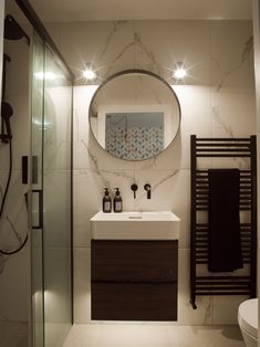 a bathroom with a sink, mirror and towel rack on the wall next to it