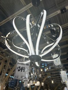 a chandelier hanging from the ceiling in a store with price tags on it