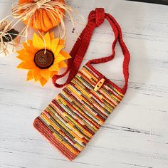 a crocheted purse sitting next to a sunflower