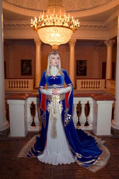 a woman dressed in blue and white is posing for the camera