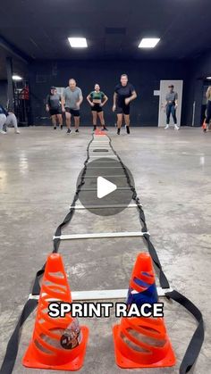 a group of people in a gym playing frisbee with cones on the ground