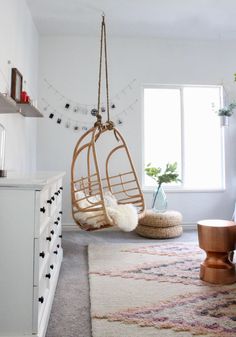 a living room with a swing chair and rug