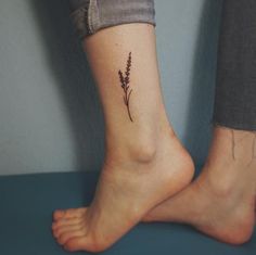 a woman's foot with a small flower tattoo on her left side calfocks