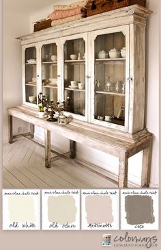 an old white china cabinet with glass doors and drawers in the center is painted gray