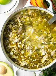 a large pot filled with soup next to an avocado