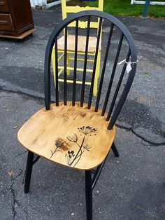 a black and yellow chair sitting on top of a street next to a wooden table