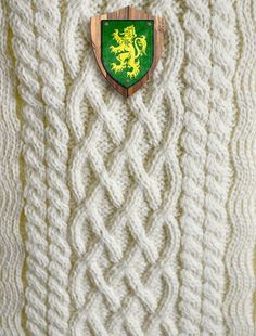 a white sweater with a green and yellow crest on it