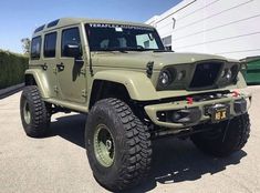 a green jeep parked in front of a building