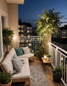 the balcony is lit up with lights and potted plants on the table next to the couch