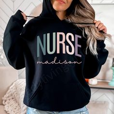 Wrap yourself in cozy confidence with our Nurse hooded sweatshirt, featuring a splash of personalization in your choice of color! Perfect for those long shifts or off-duty chill days, this hoodie lets everyone know you're a healthcare hero with a flair for style! * 50% pre-shrunk cotton, 50% polyester * Fabric weight: 8.0 oz/yd² (271.25 g/m²) * Air-jet spun yarn with a soft feel and reduced pilling * Double-lined hood with matching drawcord * Quarter-turned body to avoid crease down the middle * Personalized Long Sleeve Cotton Hoodie, Casual Personalized Hooded Hoodie, Personalized Cotton Hoodie For Winter, Customizable Long Sleeve Winter Hoodie, Casual Hoodie With Name Print For Winter, Winter Hoodie With Name Print, Casual Winter Hoodie With Name Print, Christmas Gifts For Nurses, Nursing Hoodie