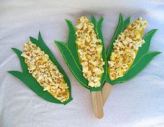 three corn on the cob sticks with toppings