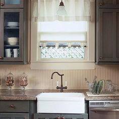 a kitchen with brown cabinets and a white dishwasher under a window in the corner