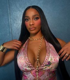 a woman in a pink and white swimsuit posing for the camera with her hands on her hips