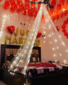 there is a canopy bed with red balloons hanging from it's headboard and lights on the ceiling