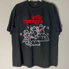 an arctic monkeys t - shirt hanging on a wall