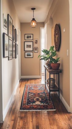 a hallway with pictures on the wall and a rug on the floor in front of it