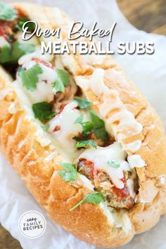 a close up of a meatball sub on a piece of paper with the words oven baked meatball subs