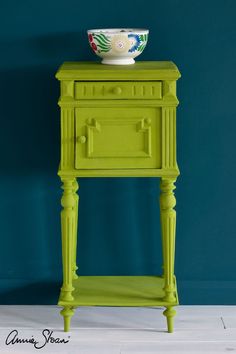 a green table with a bowl on top