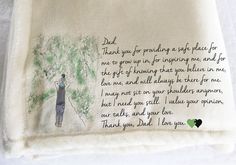 an embroidered handkerchief with a poem written on it and a person standing next to a tree