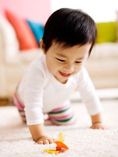 a baby crawling on the floor playing with a toy