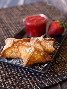 two pastries on a plate with strawberries next to them