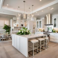 a large kitchen with white cabinets and an island in the middle is surrounded by stools