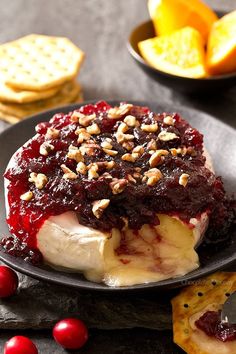 cheesecake with cranberry sauce and crackers on the side, ready to be eaten