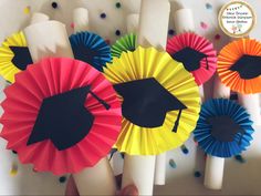 graduation decorations made out of colored paper and black caps with tassels on them