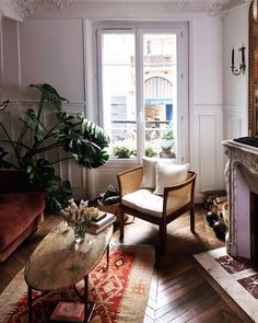 a living room filled with furniture and a fire place in front of a window next to a fireplace