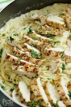 chicken and pasta in a skillet with parsley on the side, ready to be eaten