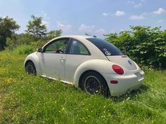 a small white car parked in the grass