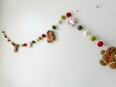 gingerbreads and christmas decorations are hung on the wall in front of a white wall