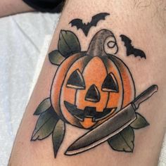 a tattoo with a pumpkin and knife on it