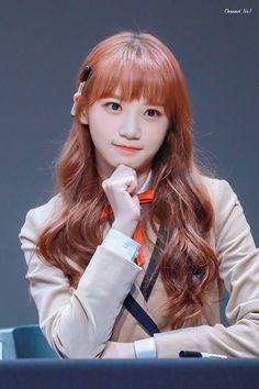 a woman with long red hair sitting at a table