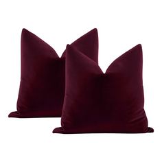 two burgundy velvet pillows on white background