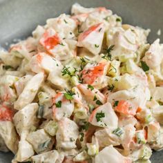 a bowl filled with chicken salad and garnished with parsley on the side