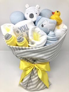 a baby boy gift basket with teddy bears and other stuff items in it's wrap