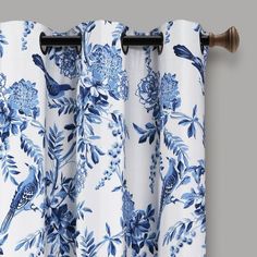 blue and white floral curtains hanging on a curtain rod